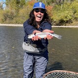 Girl in a river holding a fish. 